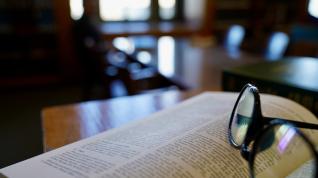 Reading glasses on top of an open book in a law library. 